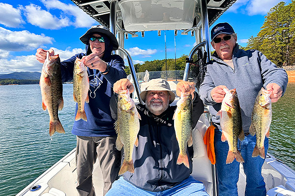 Family holds up their fish caught on a 10-hour lake fishiing trip.