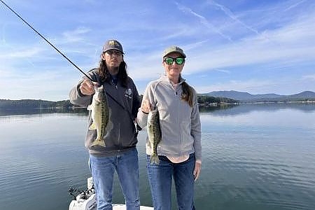 Man and woman pose together with their fish.