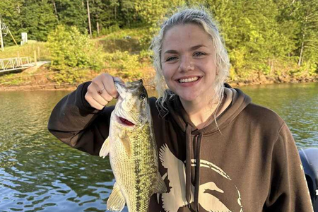  Young woman poses with fish caught on expedition.