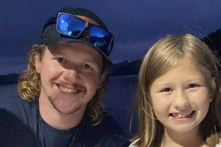  Father and daugher pose for camera aboard boat.