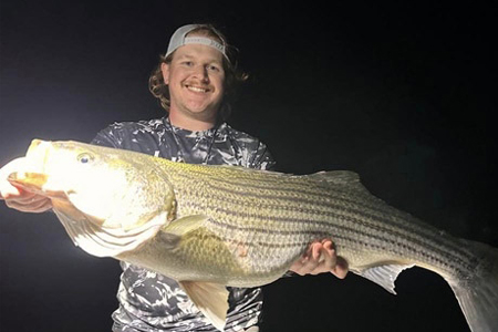  Man proudly poses with huge fish caught on night fishing trip.