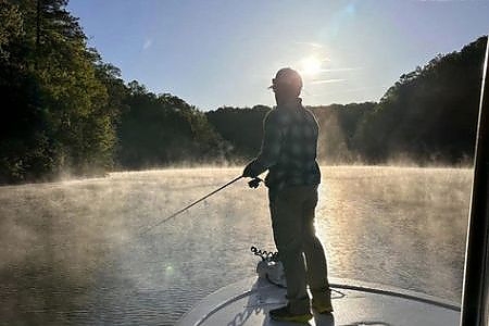  View of man fishing from cabin of lake boat.