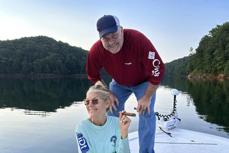  Man and woman pose together on boat.