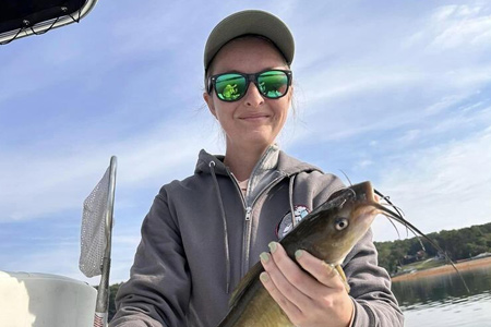  Close-up view of woman and fish on lake.