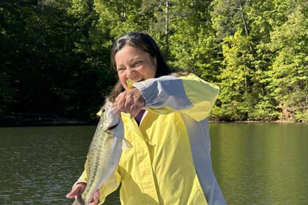   Woman in yellow jacket poses with fish caught on 4-hour trip.