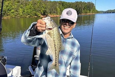  Young man holds up fish caught on 6-hour lake fishing trip.